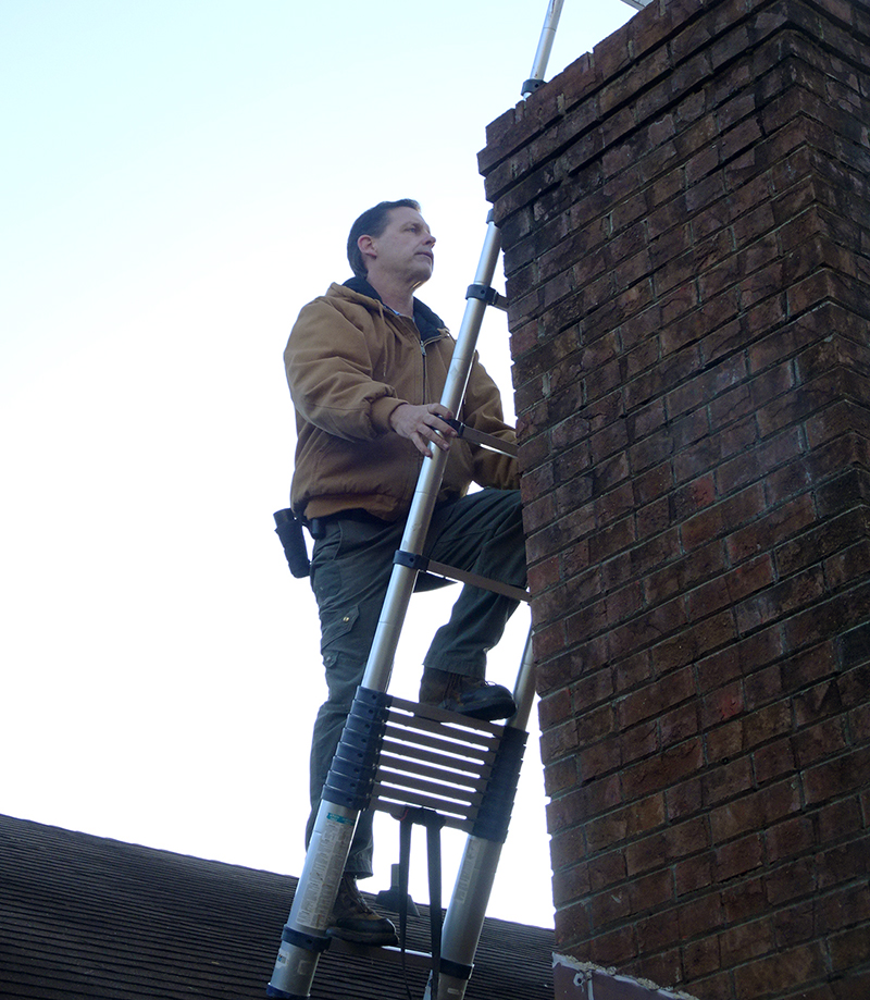Donald Eighme climbing a ladder on a roof during home inspections