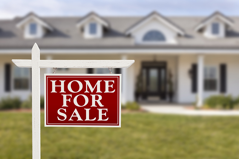 For sale sign in front of a house after thorough home inspections services were preformed