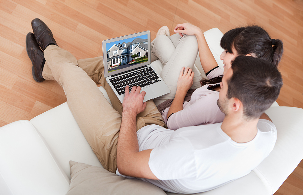 Young couple using a laptop to view their online home inspections report