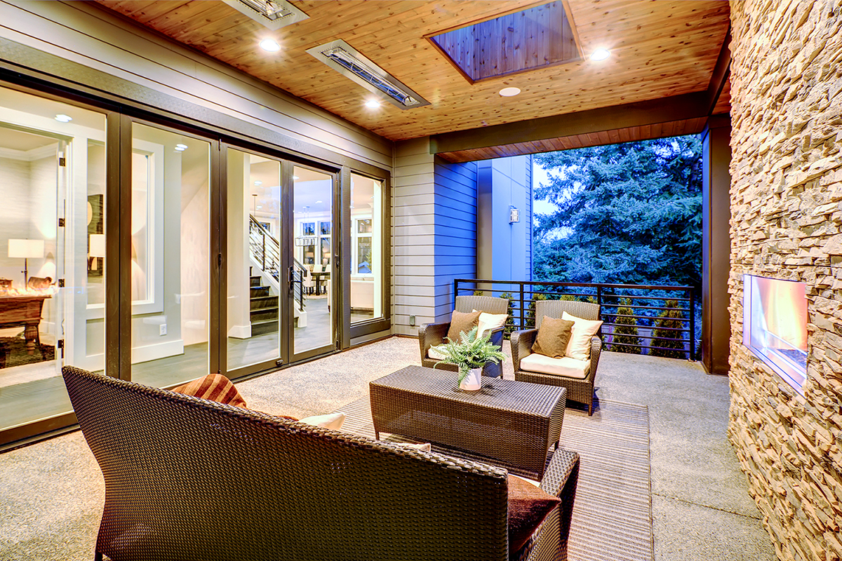 Luxury deck modern exterior with stone fireplace and wooden ceiling seen while preforming services for home inspections